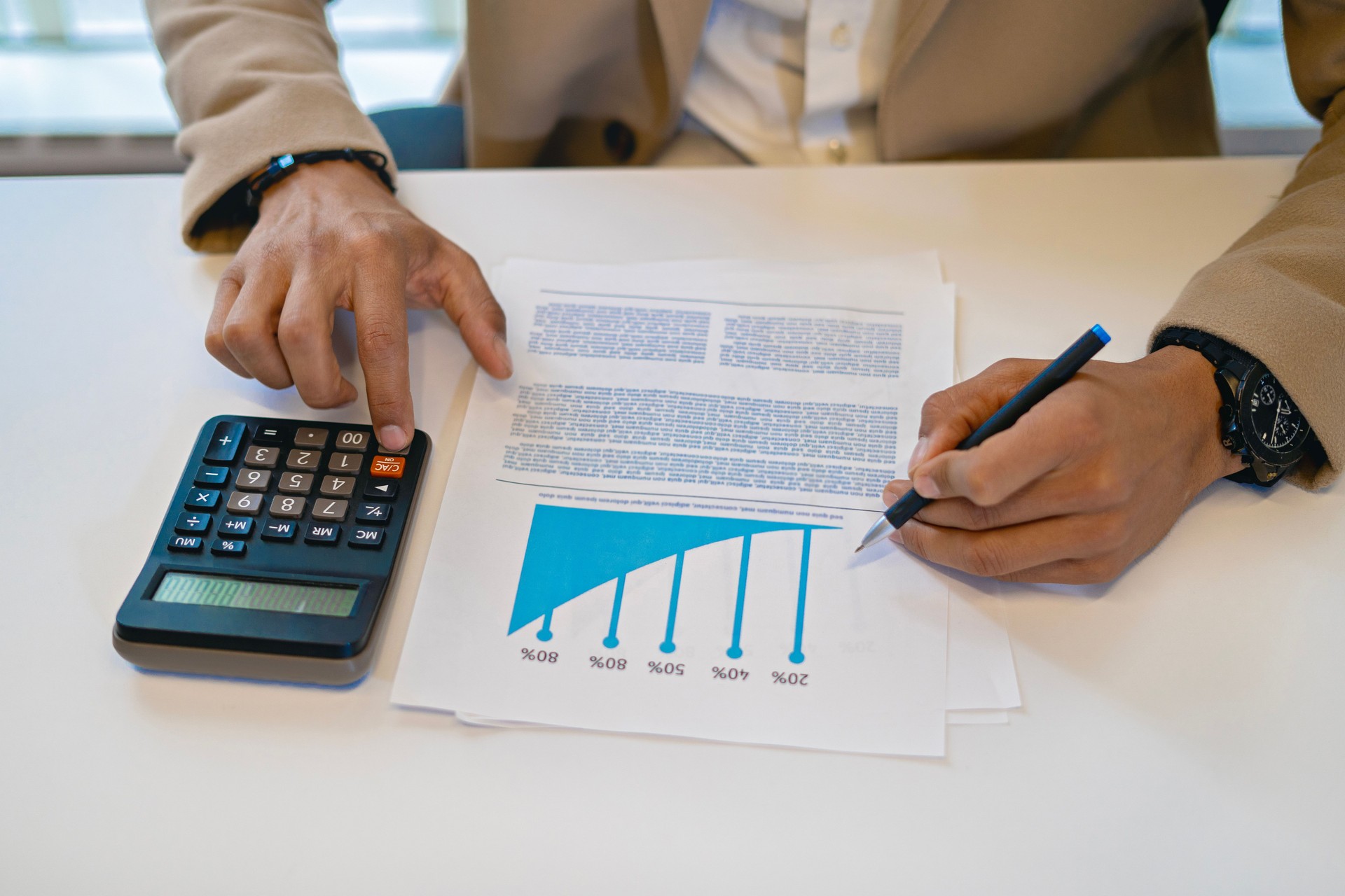 Closeup of businessman hands with calculator on his desk.